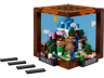 LEGO Minecraft 21265 L'établi ouvert montrant le diorama intérieur avec paysage montagneux, arbres, cascade et mini-figurines avec plaques décoratives