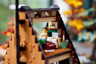 Vue rapprochée de la chambre sous les combles du chalet LEGO avec minifigurine dans le lit et tableau décoratif
