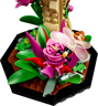 Détail du socle hexagonal du papillon LEGO avec fleur rose, abeille miniature aux ailes translucides et feuillage tropical