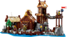 Vue de face du set LEGO Ideas 21343 Le Village Viking avec grande salle, tour de guet, forge et minifigurines vikings au bord de l'eau
