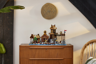 Le Village Viking LEGO Ideas 21343 exposé sur une commode en bois vintage dans un salon moderne comme pièce de décoration