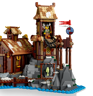 Gros plan sur la tour de guet du village viking LEGO avec minifigurine archer, bouclier décoré, drapeau rouge et poissons séchés