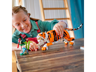 Enfant jouant avec le tigre LEGO Creator 31129 sur une table en bois avec le décor oiseau rouge et bambou