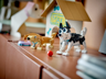 Mise en scène des chiens LEGO Creator : husky et teckel exposés sur un meuble devant une niche en carton décorée Max