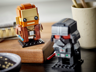 Gros plan des figurines LEGO BrickHeadz Obi-Wan Kenobi et Dark Vador posées sur un plateau en bois décoratif