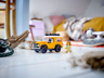 Mise en scène du LEGO Land Rover Defender jaune avec minifigurine sur un sol blanc dans un décor intérieur cosy