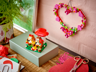 Mise en scène du LEGO 40711 Le pique-nique des hérissons sur un bureau avec une couronne en forme de cœur LEGO au mur