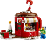 Vue de face du stand de chocolat chaud LEGO 40776 en forme de tasse rouge avec minifigurines et sapin de Noël