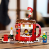 Set LEGO 40776 Le stand de chocolat chaud posé sur une table en bois avec décor de Noël en arrière-plan