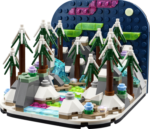 Vue rapprochée du diorama LEGO 40785 aurores boréales avec sapins enneigés, rochers et ciel nocturne coloré