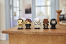 Les cinq BrickHeadz Star Wars exposés sur un meuble en bois dans un intérieur moderne, vue de face en situation de décoration