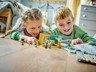 Deux enfants jouant avec le set LEGO Friends 41754 La chambre de Léo sur un parquet, ambiance chambre d'enfant