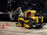 Modèle alternatif tracteur à chenilles jaune et noir du set LEGO Technic 42121 2-en-1 posé dans un décor d'atelier