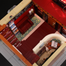 Vue plongeante de l'intérieur du rez-de-chaussée avec hall d'accueil, canapé rouge, carrelage décoratif et billetterie