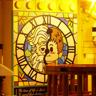 Détail intérieur d'un tableau style vitrail représentant deux personnages devant une horloge avec citation en bas