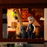 Minifigurine du vieux meunier aux cheveux blancs à l'intérieur du moulin avec engrenages et lanterne éclairée