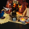Détail de l'entrée de la mine avec rails, squelette de bison, tente, feu de camp lumineux et ustensiles de cuisine