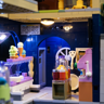 Gros plan sur l'intérieur de la boutique avec vitrine de glaces, cornets colorés et machine à gelato rose