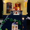 Détail du balcon bleu marine avec deux minifigurines souriantes, plantes grimpantes et éclairage LED