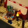 Détail du cow-boy Lumibricks regardant des conserves empilées près d'une torche LED allumée à l'extérieur du chapiteau