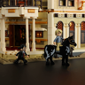 Figurines western devant l'entrée à colonnes de la banque Gold Rock avec cavalier sur cheval noir
