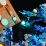Détail des branches de l'arbre bleu avec LED turquoise illuminant les fleurs translucides près du toit
