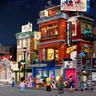 Scène de rue nocturne avec le Boxing Club Lumibricks illuminé et minifigurines dans un quartier animé