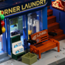 Gros plan sur la devanture de la laverie Corner Laundry avec banc graffité et flyers Flash Event