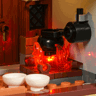 Détail intérieur de la cuisine du château Lumibricks L9119 avec chaudron sur feu LED rouge, bols blancs et cheminée en briques