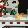 Gros plan sur un corbeau en briques posé sur les créneaux du château Lumibricks L9119 avec éclairage LED ambré en arrière-plan